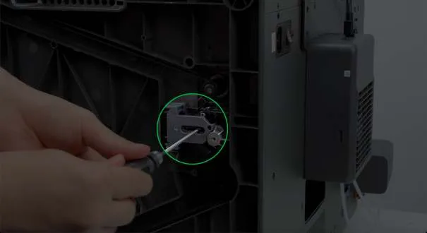 Рука ослабляет натяжной винт оси Z шестигранным ключом, выделено зелёным кружком